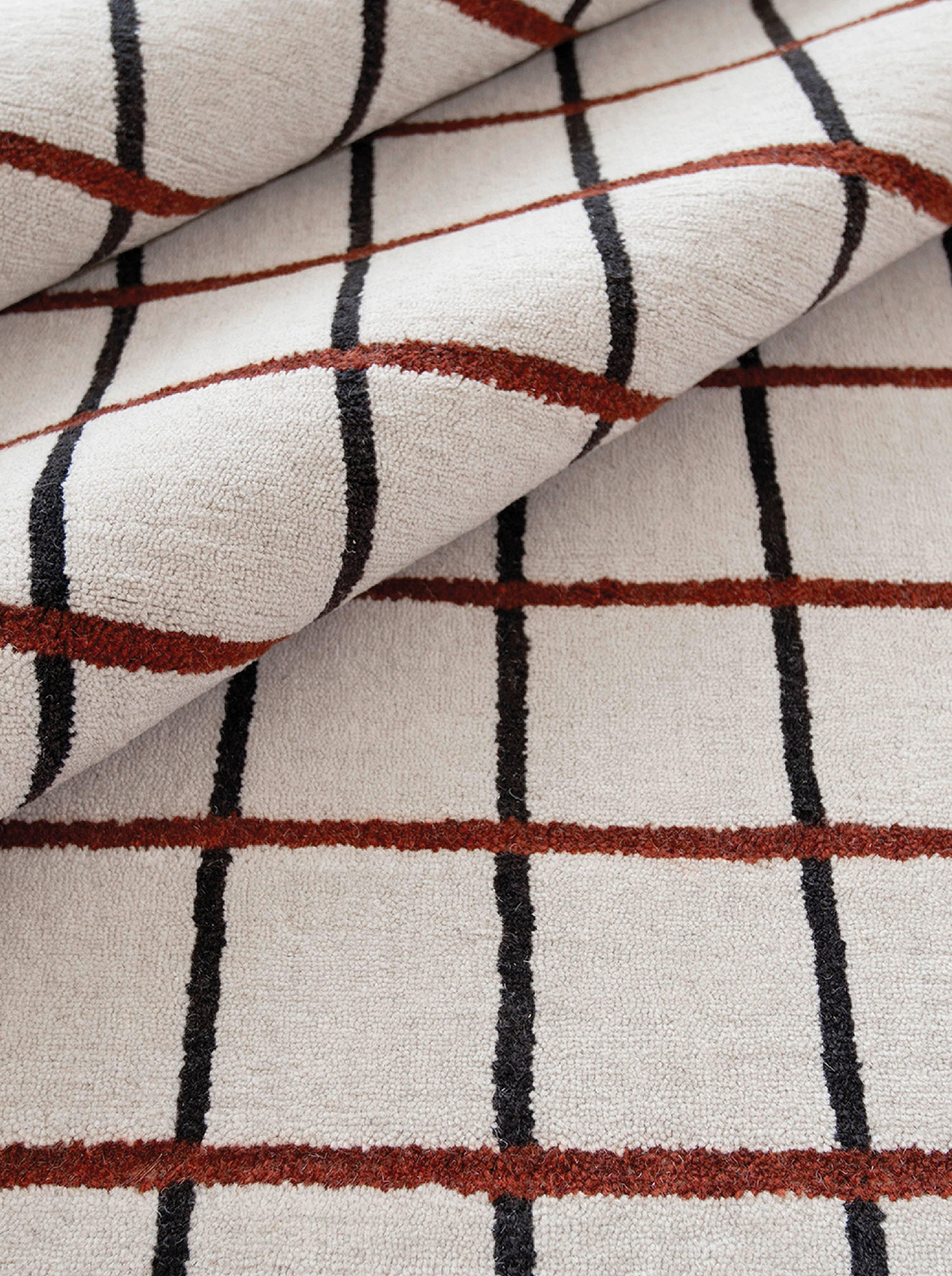 A white and black rug with a red stripe.