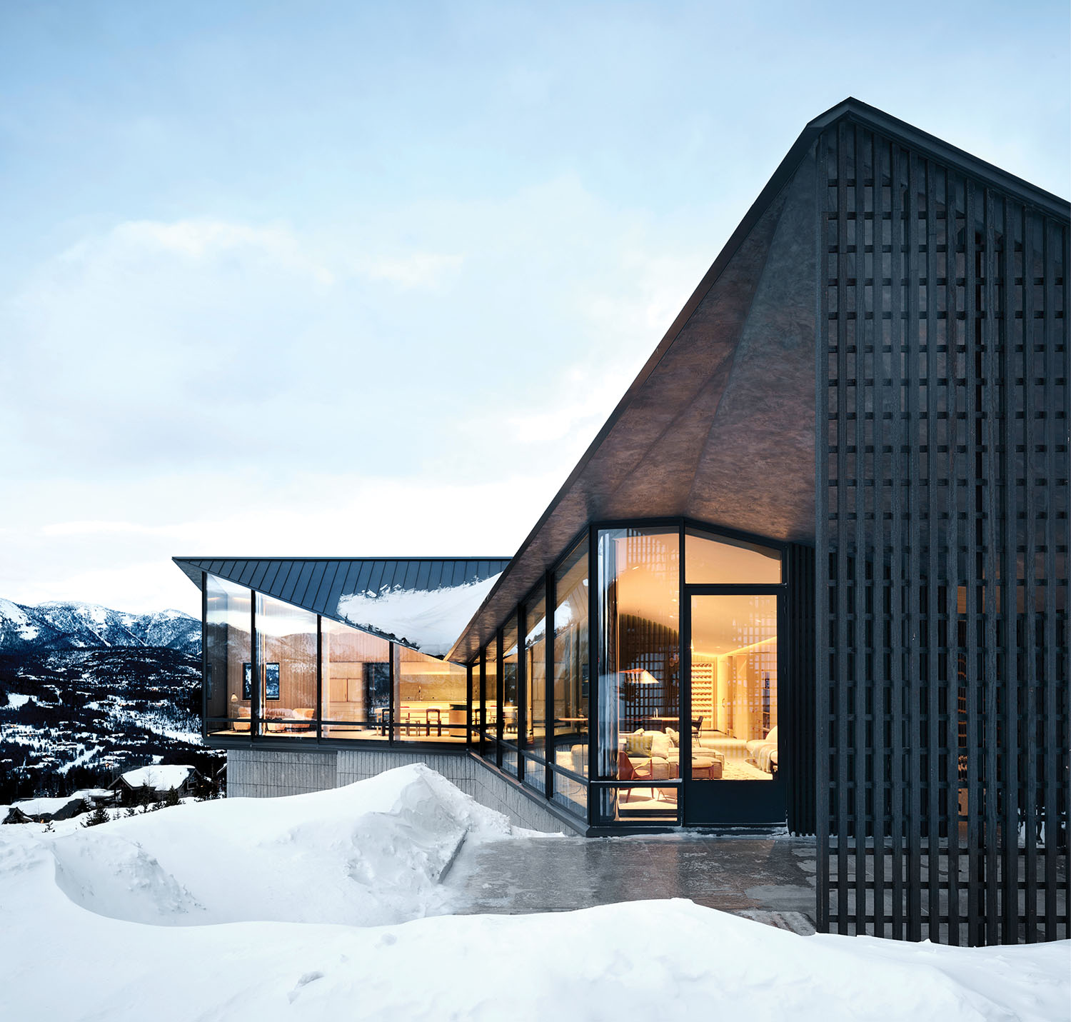 A house with a large glass window and a snowy landscape