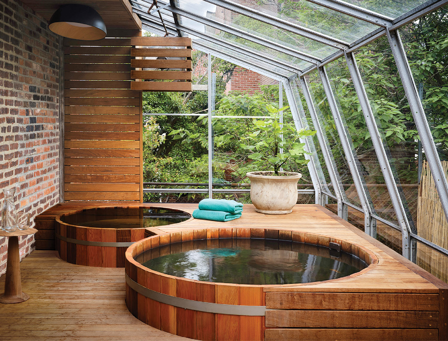 A hot tub in a wooden deck with a glass roof.