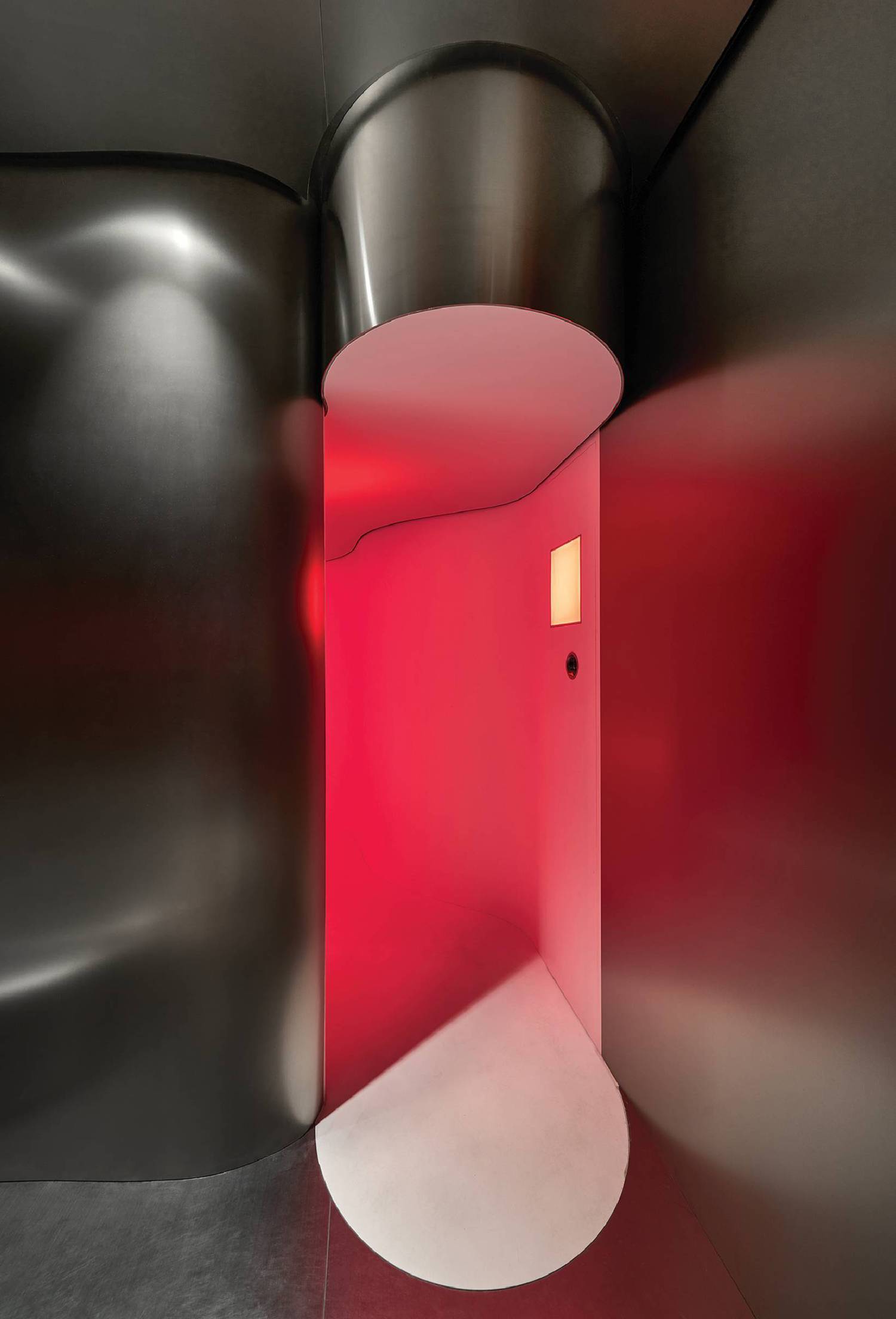 A red light shining through a white tunnel