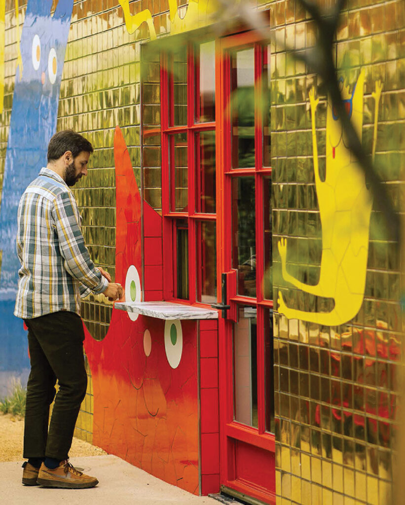 A man is opening a red door