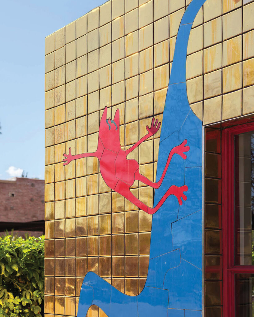A blue lizard on a yellow wall
