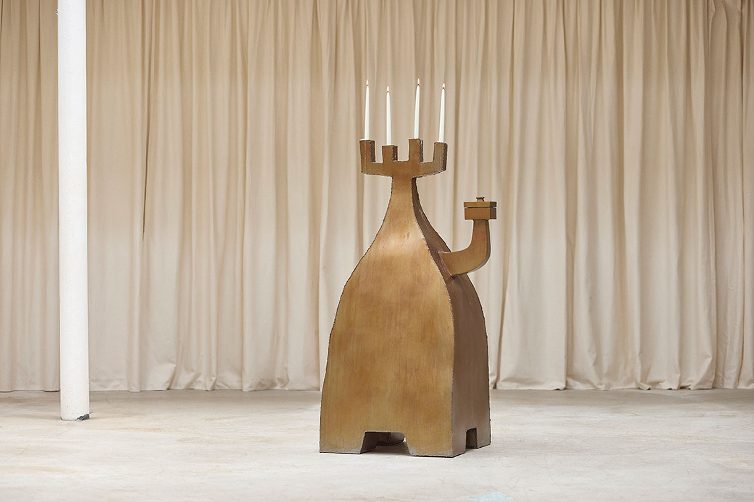 A wooden sculpture with a candle on top