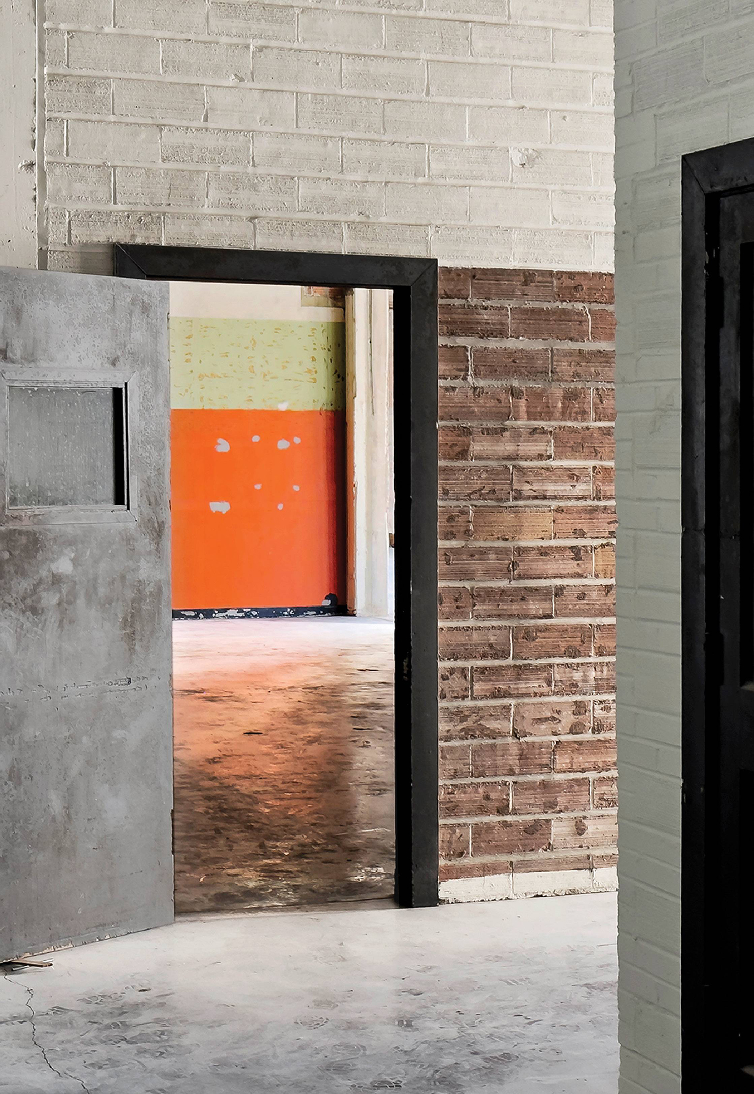 A black door in a room with a brick wall