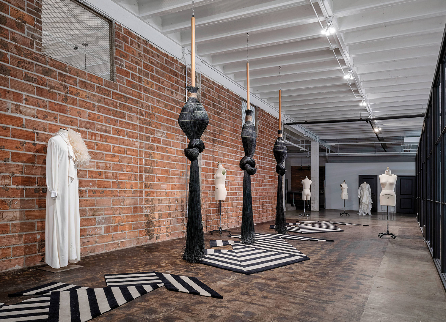 A room with a brick wall and a black and white rug