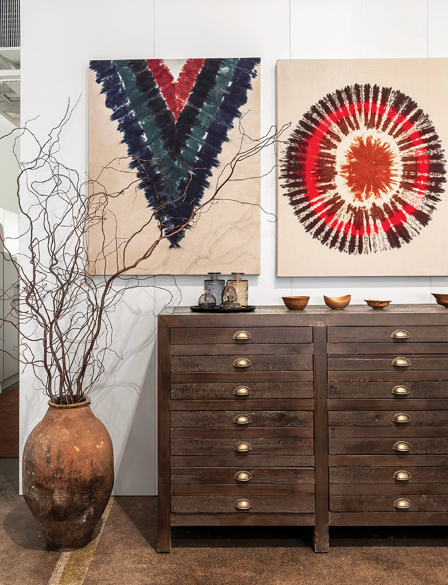 A large painting on a wall above a dresser