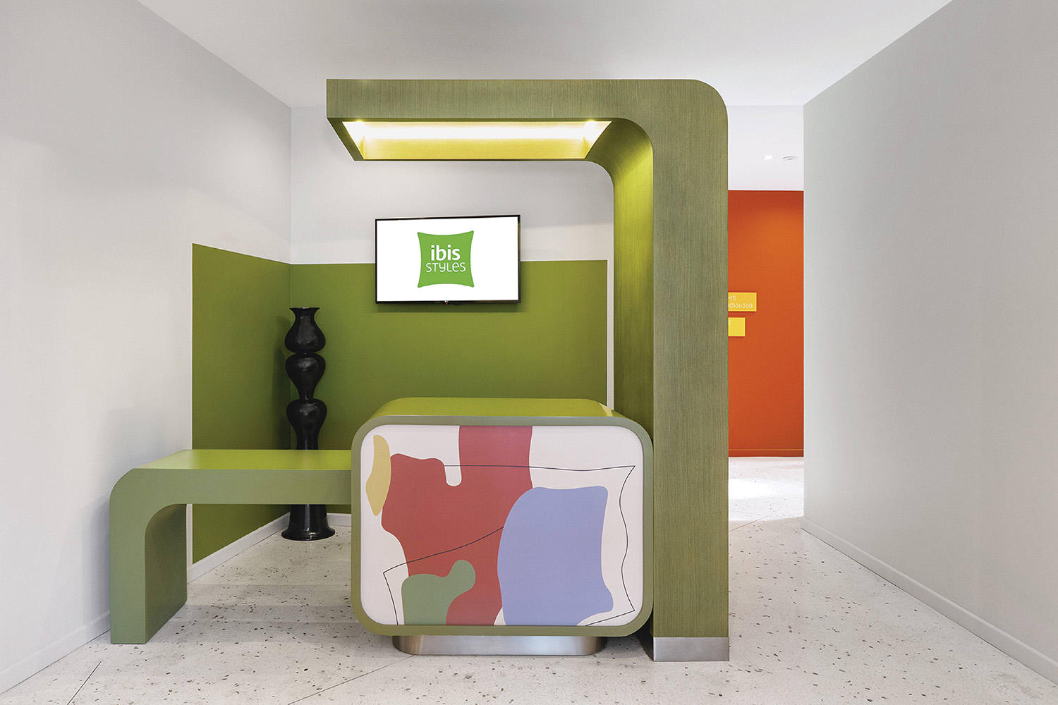 A green and white room with a tv and a green chair