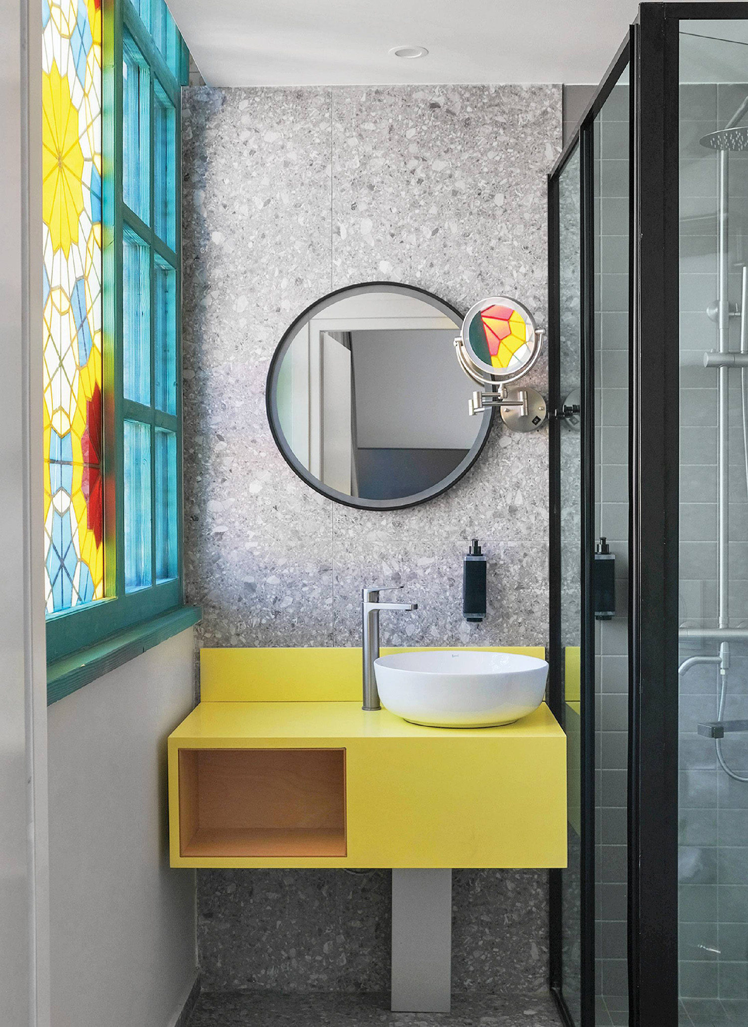A bathroom with a yellow sink and a mirror