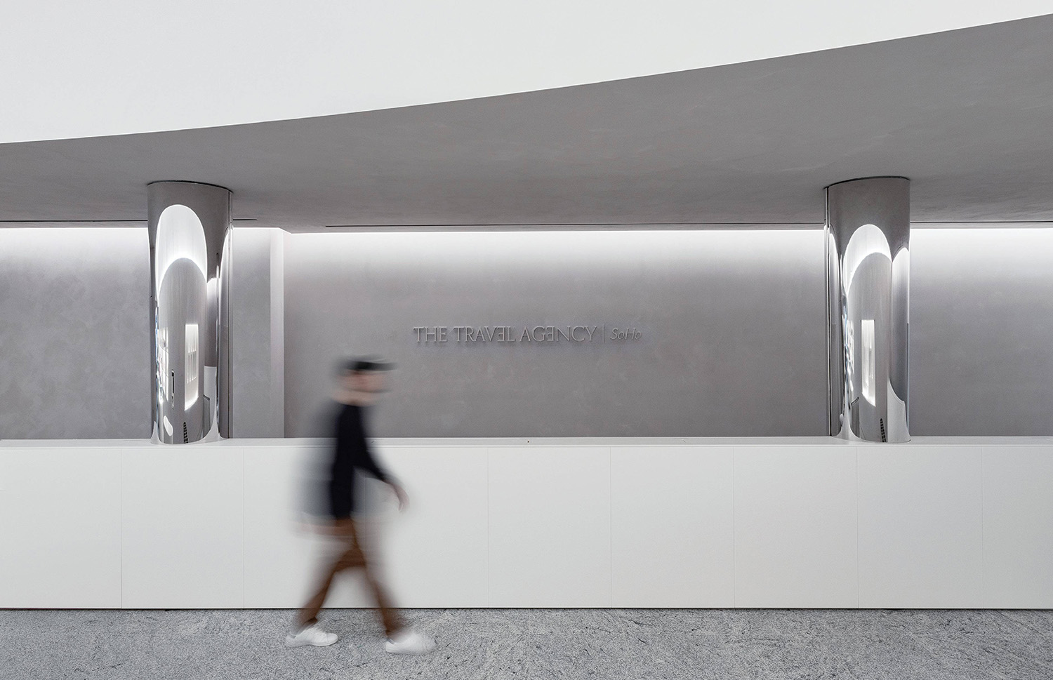 A man walking past a large metal sculpture