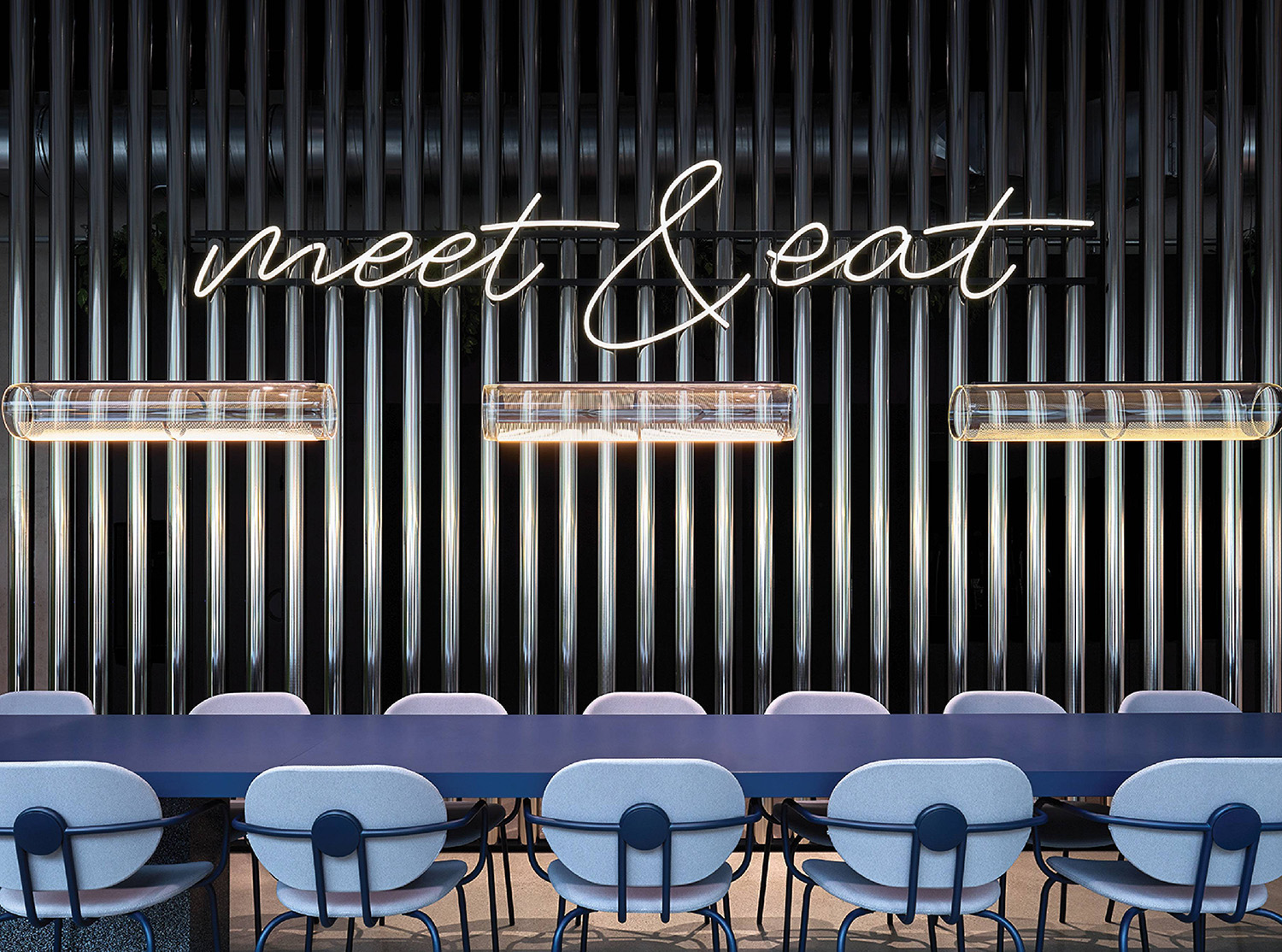 A long table with chairs and a neon sign