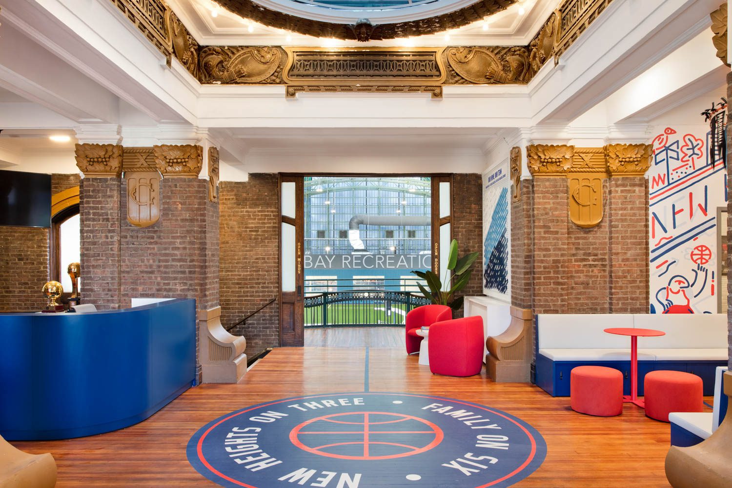 Behind the custom desk by Fabricant Brands, a second floor balcony offers prize views of the sporting events downstairs.