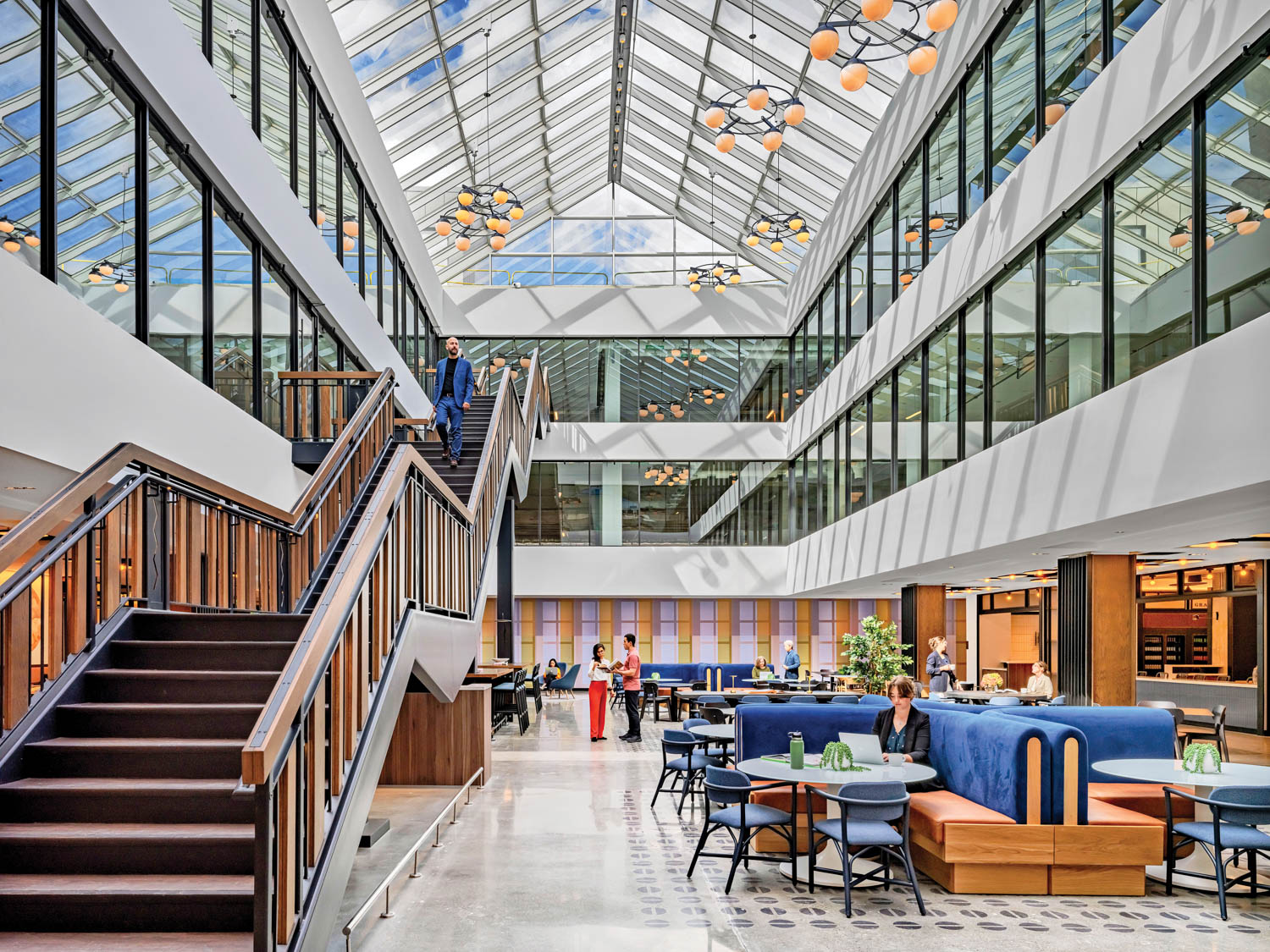 sitting area with long staircase, blue seating and enclosed hallways