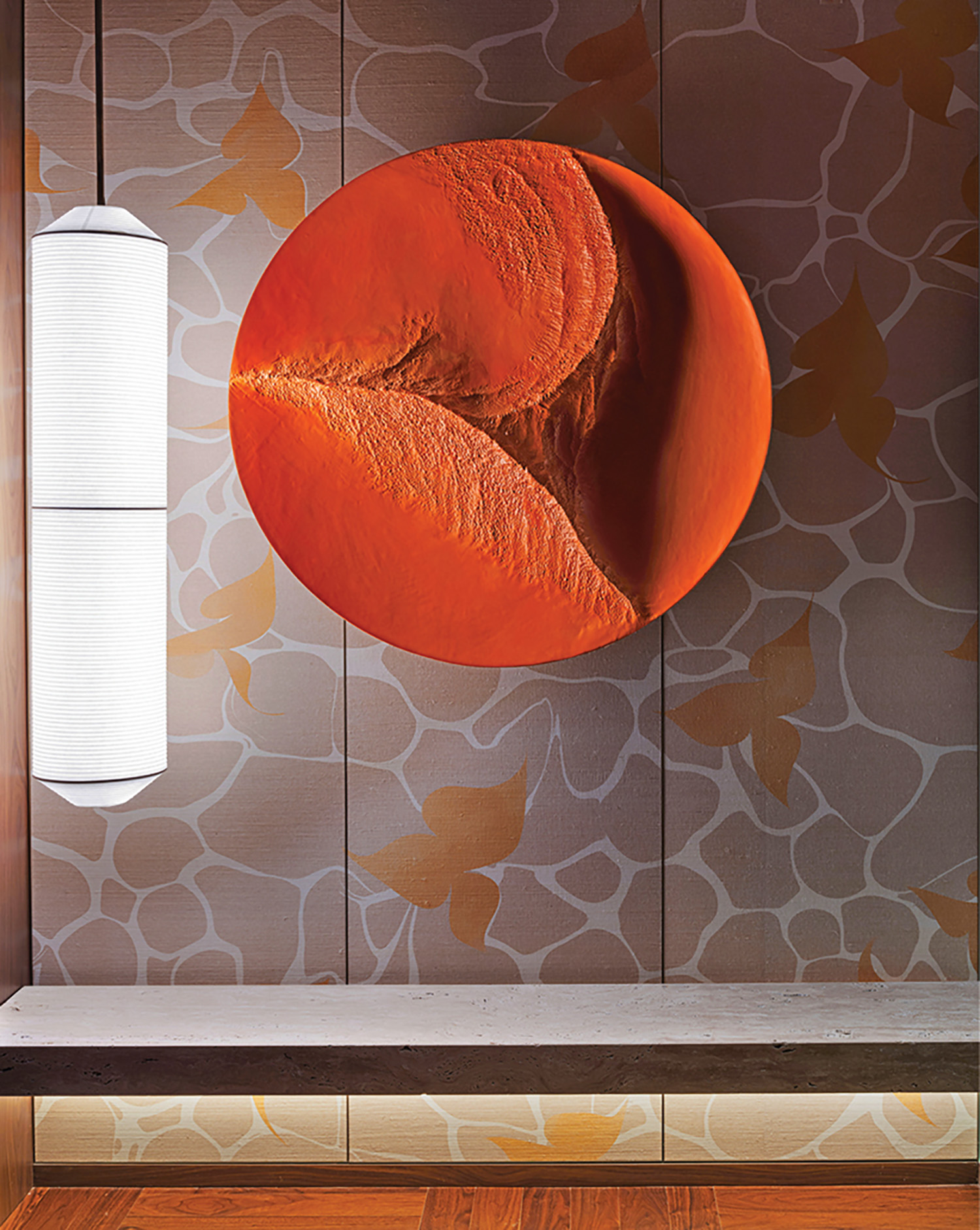 A wall with a large orange piece of art on it.
