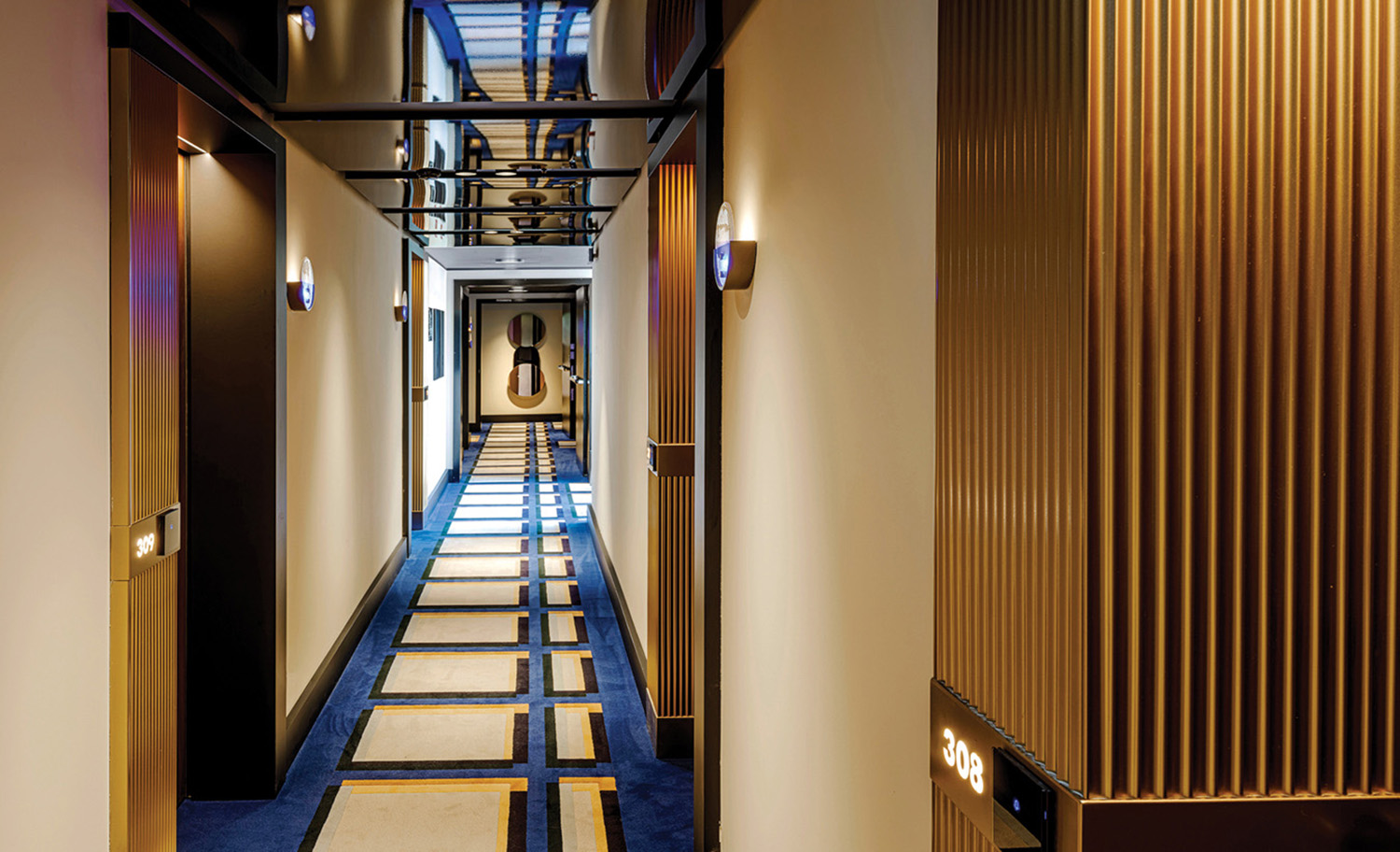 A long hallway with a blue carpet and a wooden wall.