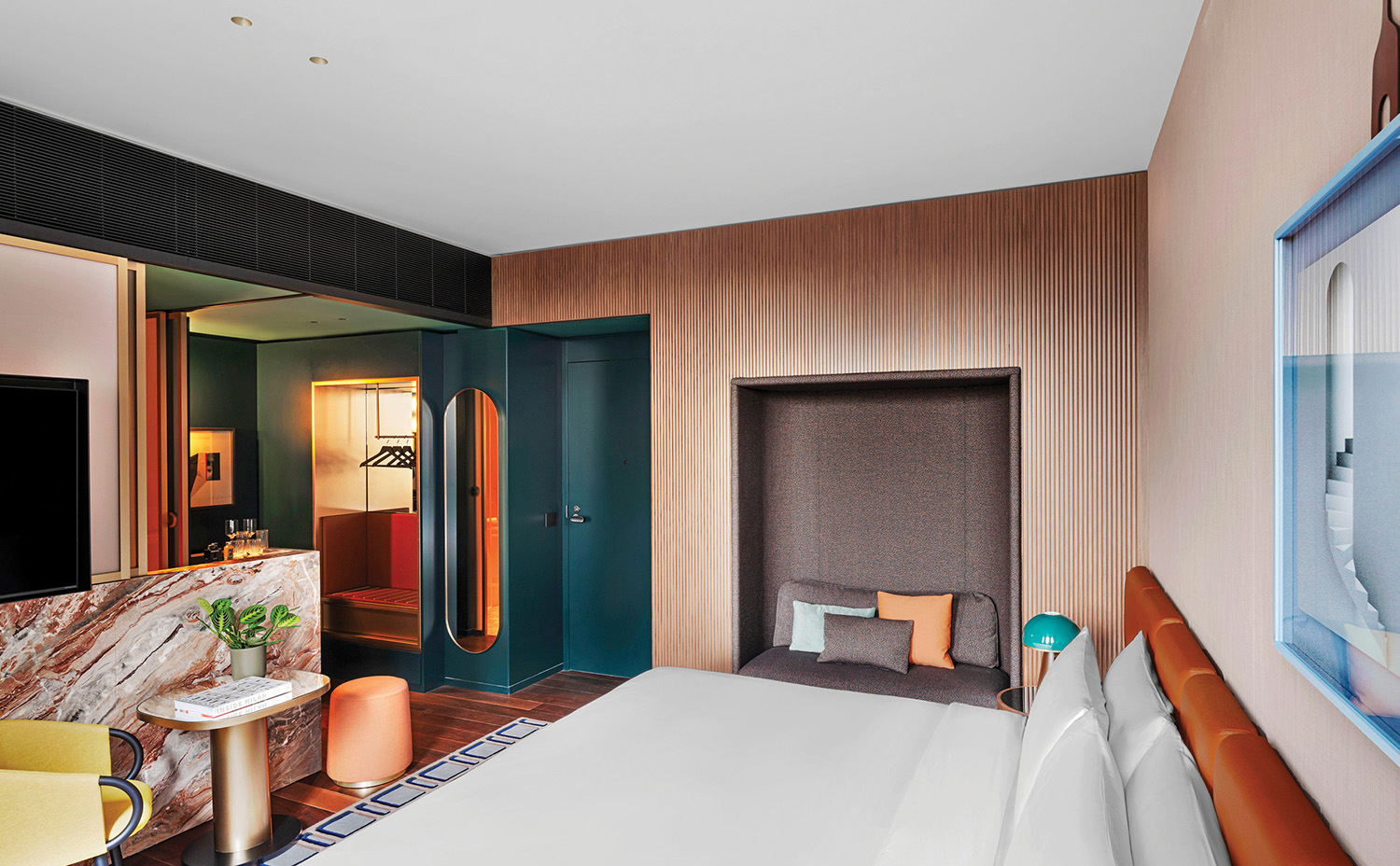 A hotel room with a bed, a television, and a desk.